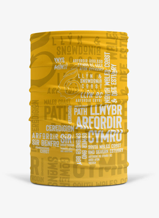 Mustard yellow multi-functional face covering featuring place names from the Wales Coast Path