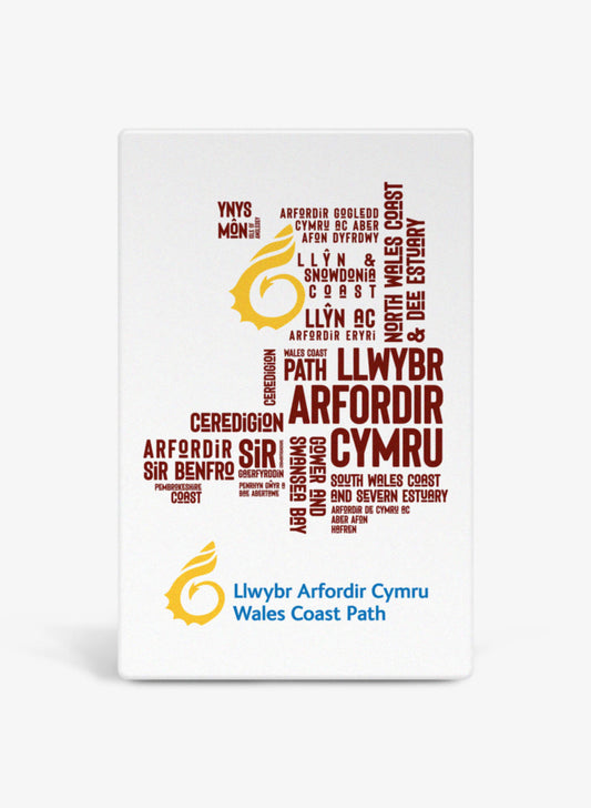 White ceramic fridge magnet featuring place names from the Wales Coast Path.