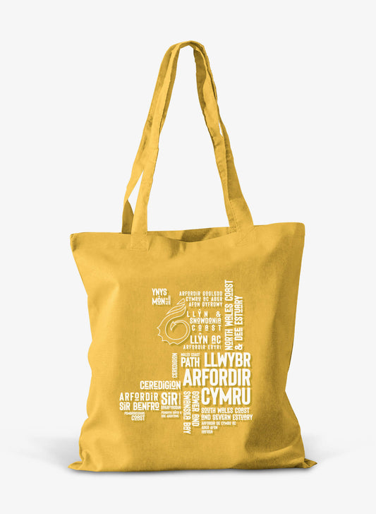 sunflower yellow cotton shoper bag  featuring place names from the Wales Coast Path