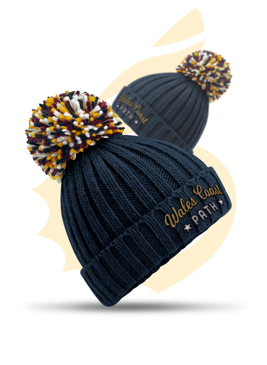 Embroidered navy Wales Coast Path chunky knitted beanie with cuffed design and multi-coloured pom pom.